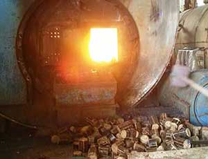 an industry boiler is burning with biomass briquette on the ground