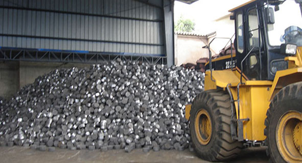 bucket loader loads aluminum briquette in warehouse